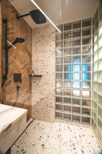 y baño con ducha con pared de cristal. en Fish'Inn Zell - Hotel Fischerwirt en Zell am See