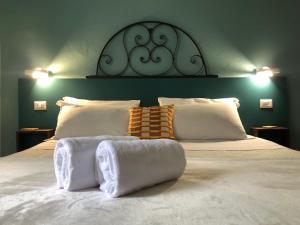 1 dormitorio con 1 cama grande y toallas. en DIMOR'A' ROOMS, en Pitigliano