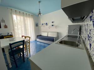 cocina con fregadero y mesa con sofá en Residence Ambra, en Lido di Jesolo