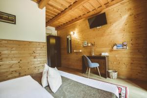 a bedroom with a wooden wall with a bed and a desk at Casa Mister in Sulina