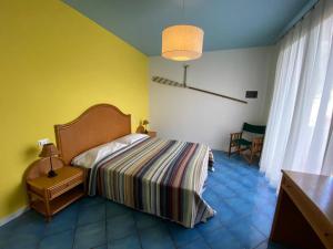 1 dormitorio con cama y pared amarilla en Residence Ambra, en Lido di Jesolo