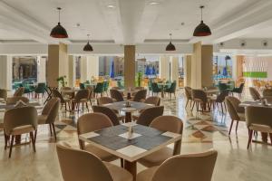 塞得港Helnan Hotel - Port Fouad的有桌椅和窗户的餐厅