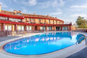 a large swimming pool in front of a building at Exe Layos Golf in Layos