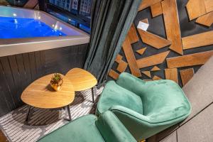 Un balcón con mesa y sillas y una bañera. en Spa on the walls - Mamilla View - Jerusalem ספא על החומות ירושלים, en Jerusalén