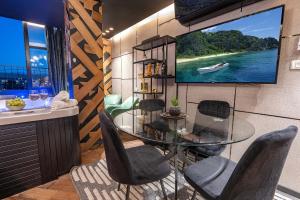un comedor con una mesa de cristal y un televisor en la pared en Spa on the walls - Mamilla View - Jerusalem ספא על החומות ירושלים, en Jerusalén