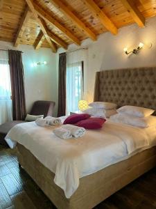 a bedroom with a large bed with towels on it at Harmonia Bungalows & Pool in Sveti Stefan