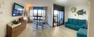 a living room with a blue couch and a table at Casa Susanna Apartment Costa del Silencio in Costa Del Silencio