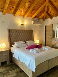 a bedroom with a large bed with two pillows at Harmonia Bungalows & Pool in Sveti Stefan