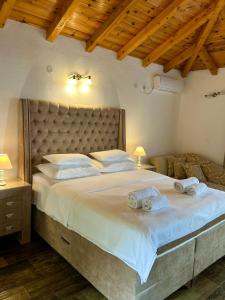 a bedroom with a large bed with two towels on it at Harmonia Bungalows & Pool in Sveti Stefan