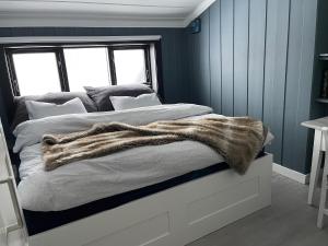 ein Schlafzimmer mit einem Bett mit einer Decke darauf in der Unterkunft Naturskjønt og sentralt, flott beliggende stor hytte in Fausko