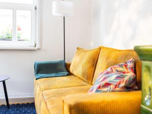 a yellow couch in a living room with a window at Ferienwohnung Brühler Hof in Bad Berka