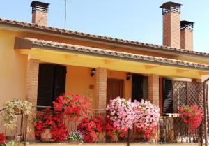 une maison avec des fleurs devant une clôture dans l'établissement Il Casaletto, à Acquasparta