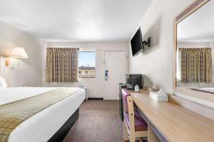 a hotel room with a large bed and a mirror at Americas Best Value Inn - Lake City in Lake City