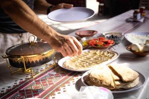 Ein Mann bereitet Essen auf einem Tisch zu in der Unterkunft Wadi Rum Mirror Camp in Wadi Rum