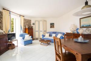 a living room with a table and blue chairs at Villa Roccia Di Mare in Capri