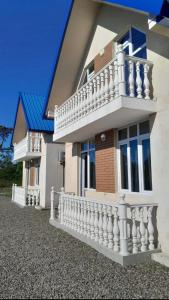 ein Haus mit einem weißen Zaun und einem Balkon in der Unterkunft Villa MATE & Villa LUKA in Ureki