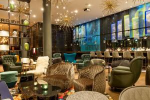 a lobby of a hotel with chairs and a bar at Motel One Bonn-Beethoven in Bonn