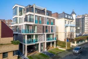 an apartment building with balconies on a city street at Trendy en stijlvol appartement aan zee - 4p in De Haan