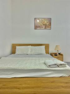1 dormitorio con cama blanca y cabecero de madera en MARIA HOTEL en Ba Tri