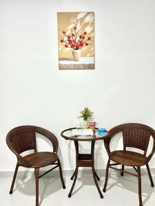 una mesa y dos sillas y una mesa y un cuadro en MARIA HOTEL, en Ba Tri