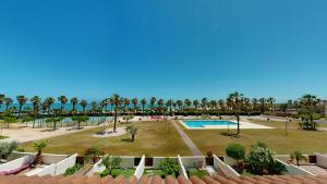 a view of a park with a pool and palm trees at Casa Raquel in L'Ampolla