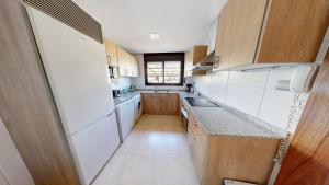 a small kitchen with white appliances and a window at Casa Raquel in L'Ampolla