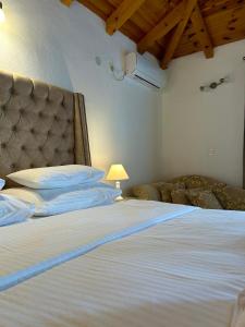 a bedroom with a large white bed with a headboard at Harmonia Bungalows & Pool in Sveti Stefan