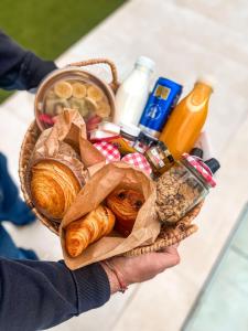 una persona con una cesta de pan y otros alimentos en Marconia Boutique Residence, en L'Estartit