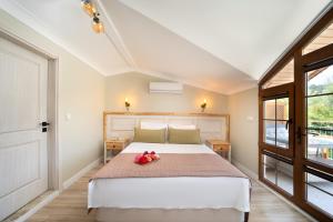 a bedroom with a bed with a red flower on it at Orange Garden Hotel Akyaka in Akyaka