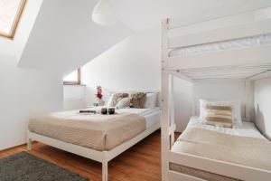 1 dormitorio con 2 literas en una habitación blanca en Brzozova Apartments Zakopane - LoftAffair, en Zakopane