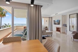 salon ze stołem i widokiem na ocean w obiekcie Front line beach luxury apartment in Heaven Beach w mieście Estepona