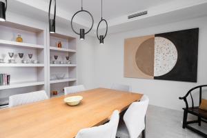 jadalnia z drewnianym stołem i białymi krzesłami w obiekcie Front line beach luxury apartment in Heaven Beach w mieście Estepona +19 zdjęć