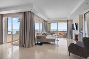 salon z kanapą, stołem i krzesłami w obiekcie Front line beach luxury apartment in Heaven Beach w mieście Estepona