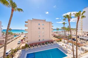 widok na hotel z basenem i palmami w obiekcie Universal Hotel Bikini w Cala Millor
