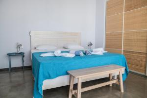 Un dormitorio con una cama con sábanas azules y una mesa. en Villa Kassandra, en Pitsidia