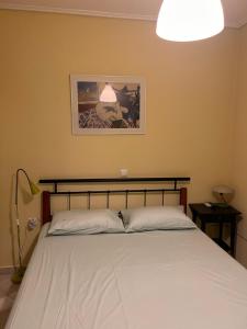 1 dormitorio con 1 cama grande con colcha blanca en Amazing view Panorama Eretrias, en Eretria