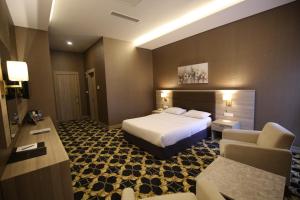 安卡拉Hotel Excellence Inn的一间酒店房间，里面有一张床和一张沙发