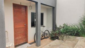 a bike parked next to a house with a door at Pousada Sonho in Apucarana