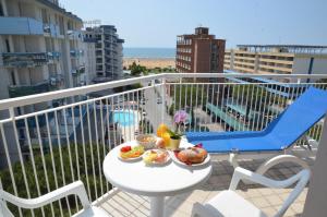 einen Teller mit Essen auf einem Tisch auf einem Balkon in der Unterkunft Hotel Luna in Bibione