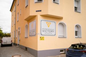 a building with a sign on the side of it at Boardinghouse Victory in Augsburg
