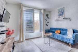 a living room with a blue couch and a window at EDEN Home in Bezons