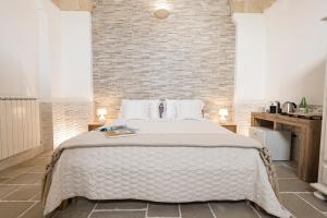 a bedroom with a bed and a brick wall at Guerrieri Suites & Spa in Campi Salentina +106 photos