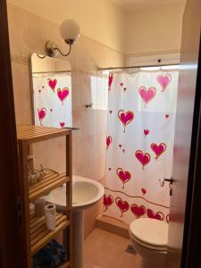 a bathroom with a shower curtain with hearts on it at Amazing view Panorama Eretrias in Eretria