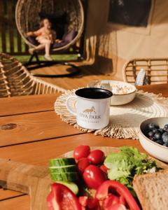une table avec une assiette de légumes et une tasse de café dans l'établissement Liva Park Glamp, à Liwa