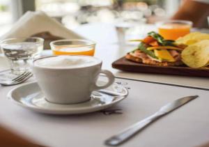 a table with a cup of coffee and a plate of food at Veneto Village - Vista al Lago - 10 minutos a Carlos Paz in Villa Parque Siquiman