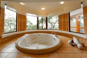 a large bath tub in a room with windows at Borinquen Thermal Resort in Liberia