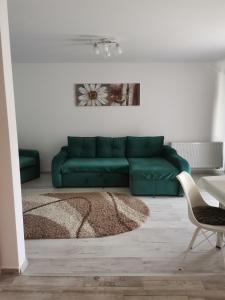 - un salon avec un canapé vert et une chaise dans l'établissement Apartmant Melinda M16, à Braşov