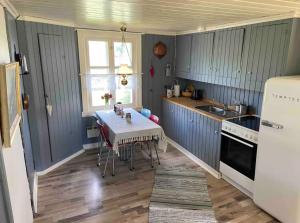 a small kitchen with a table and a sink at Farm stay in cozy cabin at Vestre Kinn in Ørje