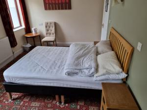 a bed with white sheets and pillows in a room at Dolphin Hotel in Beer