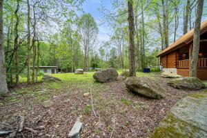 een hut in het bos met rotsen in de tuin bij Parkway Treasure cabin in Gatlinburg